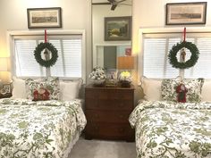 two beds in a room with christmas wreaths on them