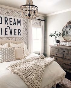 a bedroom with a bed, dresser and chandelier