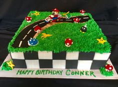 a birthday cake that is shaped like a race track with mario and luigi on it