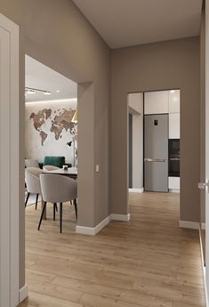 an empty living room and dining area with wood flooring in the foreground is a world map on the wall