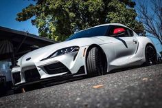 a white sports car parked in front of a house