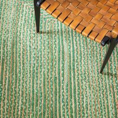 a wooden chair sitting on top of a green rug