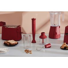 there are many red blenders on the table with toaster and other items next to them