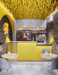 the interior of a cafe with yellow lights and chairs in front of it, as well as a counter