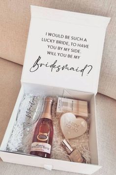 an open box with two bottles of champagne and a heart - shaped bottle in it