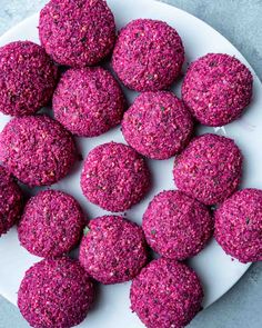 a white plate topped with pink cookies covered in sprinkles on top of a table