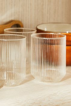 three clear glass cups sitting on top of a table