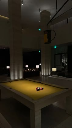 a pool table in the middle of a room with two lamps on either side of it