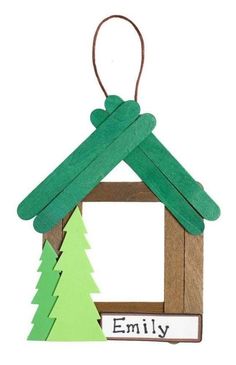 an ornament made to look like a house with trees hanging from the roof