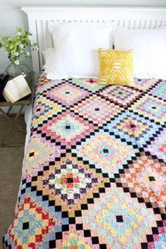 a bed with a colorful quilt on top of it