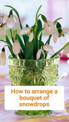 a vase filled with white flowers sitting on top of a pink tablecloth covered table