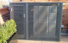 a metal gate on the side of a building next to a potted planter