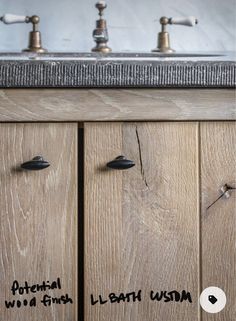 two faucets on the side of a wooden cabinet