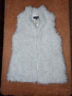 This is a faux fur off white sleeveless vest that hits below waist. It has a silky polyester lining and matching lined pockets. It has 4 Chinese inspired clasp closures along front. UK size XL. Sleeveless Faux Fur Vest For Fall, White Sleeveless Vest, Gilet Long, Long Vest, Long Vests, Daytona Beach, Frappe, White Sleeveless, Sleeveless Vest