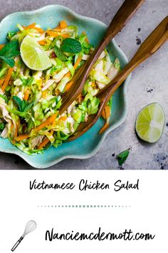 a bowl filled with vegetables and chopsticks next to a lime wedge on the side