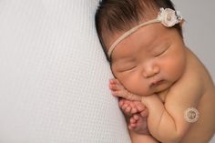 a baby sleeping on top of a white blanket