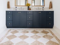 a bathroom with double sinks and two mirrors on the wall above it is tiled flooring