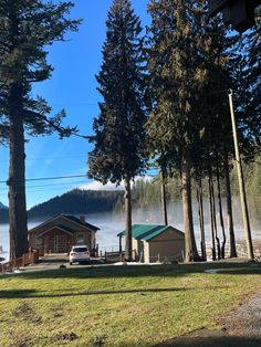 there is a small cabin in the middle of some trees near a body of water