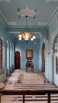 an empty room with blue walls and striped rugs on the floor, along with two wooden benches