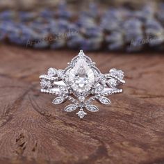 a white diamond ring sitting on top of a wooden table