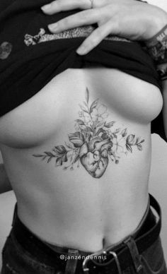 a woman's stomach with flowers and hearts tattooed on the side by tattoo artist