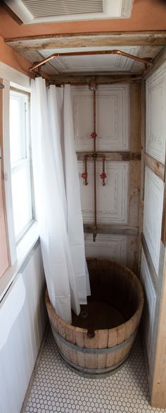 a bath tub sitting in the middle of a bathroom next to a window with curtains