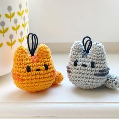 two small crocheted animals sitting next to each other on a window sill