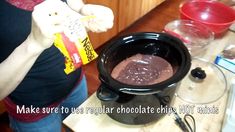 a woman is pouring chocolate into a crock pot