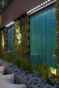 an outdoor area with plants and rocks in the foreground, along with lights on either side