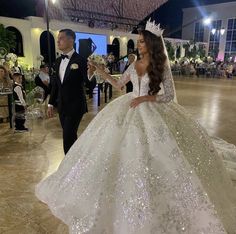 a man in a tuxedo standing next to a woman in a wedding dress