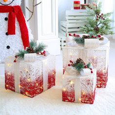 two presents are wrapped in red and white paper with lights on them, next to a snowman