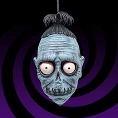 a creepy mask hanging from a string on a purple and black background with spirals