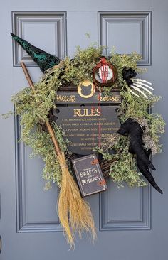 a halloween wreath on the front door of a house decorated with witches and brooms