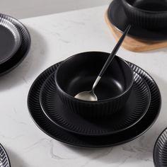 black plates and bowls with spoons in them