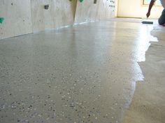 a skateboarder is doing tricks on his board in an indoor area with concrete walls and flooring