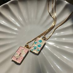 We collaborated with artist Julie Dreams to create the Tarot card necklace of our dreams. This necklaces features one kind artwork thoughtfully created by her just for us. We created this necklace in mind to pair with our Three of Cups Necklace (https://www.etsy.com/listing/1719373341/three-of-cups-tarot-pendant-necklace). Together, they make the perfect set of BFF necklaces.  Delicately detailed in enamel is our representation of the Queen of Wands card. This card is represents independence, ge Artistic Square Pendant Necklace For Gift, Artistic Pink Necklace For Gift, Artistic Enamel Necklaces As Gift, Artistic Enamel Necklaces For Gifts, Artistic Rectangular Pendant Necklace As Gift, Artistic Rectangular Pendant Necklace For Gift, Artistic Rectangular Necklace For Gifts, Artistic Rectangular Necklace For Gift, Three Of Cups Tarot