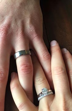 two people holding hands with wedding rings on their fingers