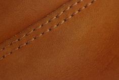 close up view of the inside of a brown leather shoe with stitching on it