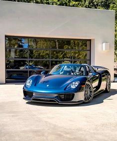 a blue sports car parked in front of a garage