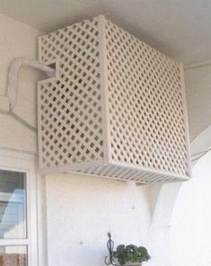 the corner of a white building with a planter on it's side and a window in the background