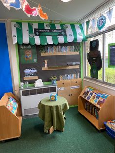 the children's library is decorated with green and white striped drapes, bookshelves, and toys