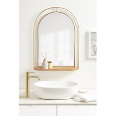 a white sink sitting under a mirror next to a gold faucet