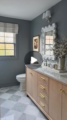 a white toilet sitting next to a sink in a bathroom under a window with curtains