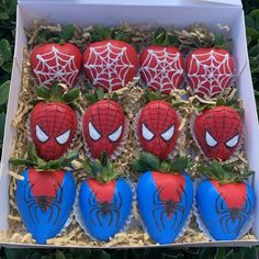 chocolate covered strawberries with spiderman decorations in a box