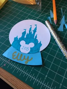 a close up of a paper cut out of mickey mouse's castle with a pencil next to it