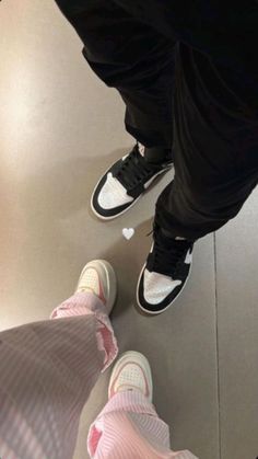 two people standing next to each other wearing sneakers