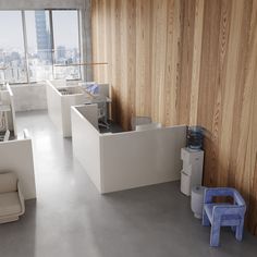 an office with wooden walls and white desks in the center, along with two blue stools