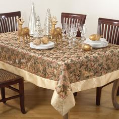 the table is set with gold and white dishes, silver candlesticks, and deer figurines