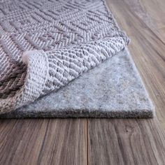 a close up of a rug on the floor with wood grained floors in the background