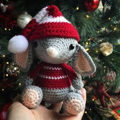 a small crocheted elephant wearing a red and white hat